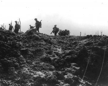 Soldiers march through a shelled battlefield.